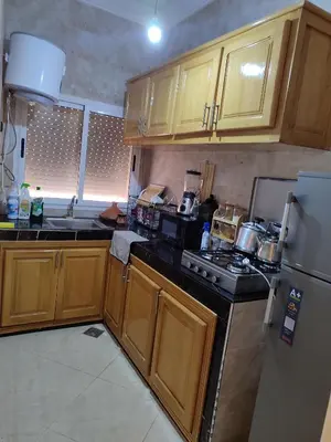 a kitchen with wooden cabinets and a stove top oven at Relaxnstay midelt in Midelt