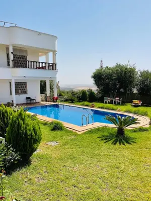 a swimming pool in the yard of a house at Ferme Erraha in Bhalil