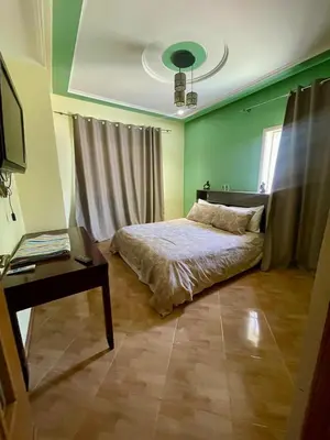 a bedroom with a bed and a table and a desk at Ferme Erraha in Bhalil
