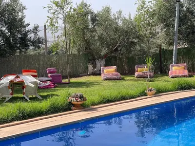 a yard with chairs and a table and a pool at Ferme Erraha in Bhalil