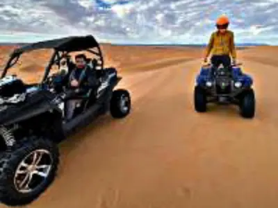 two people riding on atvs in the desert at Luxury Dune's Camp in Merzouga