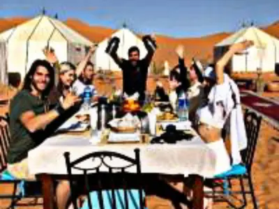 a group of people sitting around a table at Luxury Dune's Camp in Merzouga