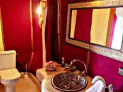 a bathroom with a sink and a mirror at Luxury Dune's Camp in Merzouga