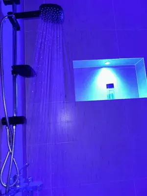 a shower with purple lighting in a bathroom at l'habitation avec la famille in Fès