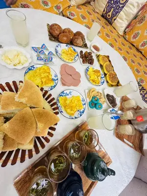 a table topped with plates of breakfast foods and drinks at l'habitation avec la famille in Fès