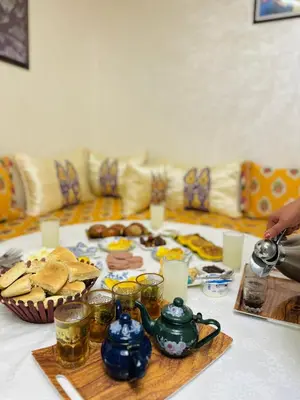 a table with a plate of food on top of it at l'habitation avec la famille in Fès