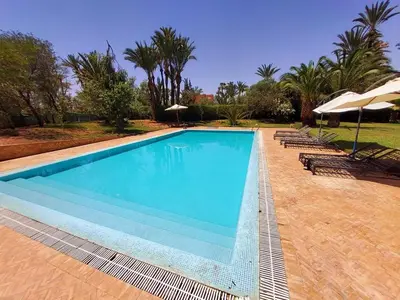 a large swimming pool with chairs and umbrellas at Marrakech LUXE in Oulad Akkou
