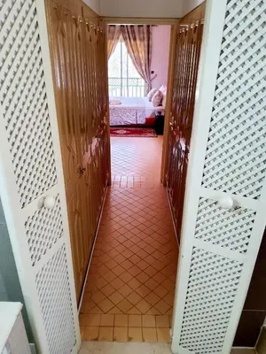 a hallway with wooden doors and a room with a bed at Marrakech LUXE in Oulad Akkou