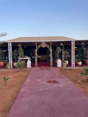 a tent with a purple carpet in front of a building at Merzouga in Merdani