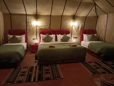 a bedroom with two beds in a tent at Tilila Luxury Camp in Merzouga