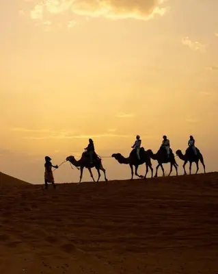 a group of people riding horses in the desert at Tilila Luxury Camp in Merzouga