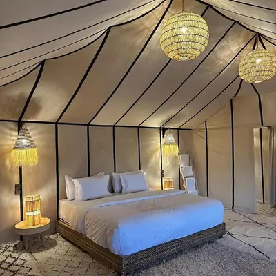 a bedroom with a bed in a tent at Tilila Luxury Camp in Merzouga