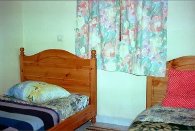 a bedroom with two twin beds and a window at le sirwa salam in Anzel