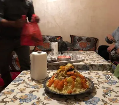 a table with a plate of food and a candle at le sirwa salam in Anzel
