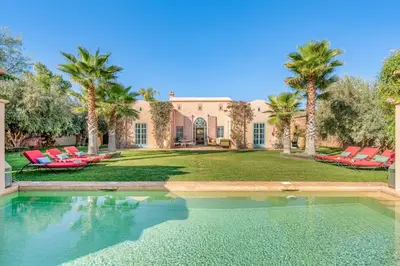 a house with a swimming pool and palm trees at Villa Cannella - Marrakech in Chaibate
