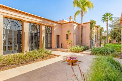 an exterior view of a house with palm trees at Villa Cannella - Marrakech in Chaibate