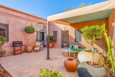 an outdoor patio with plants and an umbrella at Villa Cannella - Marrakech in Chaibate