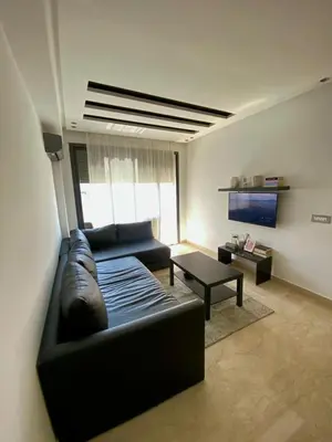 a living room with a couch and a table at Modern studio, ideal location in Oulad Akkou