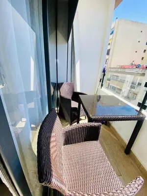 a balcony with two wicker chairs and a window at Modern studio, ideal location in Oulad Akkou