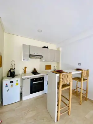 a kitchen with white appliances and a table and chairs at Modern studio, ideal location in Oulad Akkou