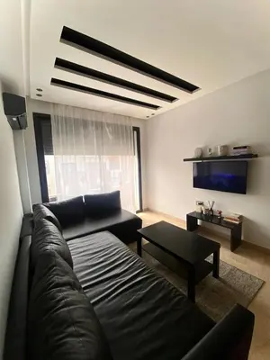 a living room with a couch and a table at Modern studio, ideal location in Oulad Akkou