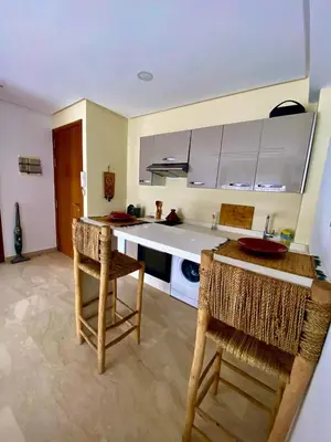 a kitchen with a table and chairs in a room at Modern studio, ideal location in Oulad Akkou
