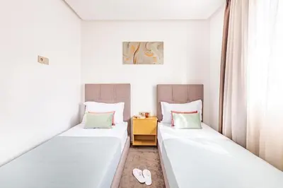 two beds in a room with two slippers at Grand Appartement avec Balcon Marrakech in Oulad Akkou