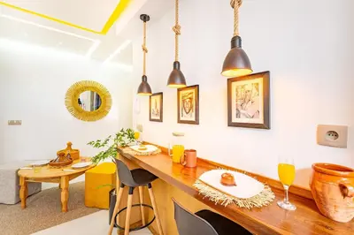 a dining room with a wooden table and some lights at Grand Appartement avec Balcon Marrakech in Oulad Akkou
