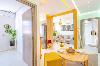 a living room with a table and a couch at Grand Appartement avec Balcon Marrakech in Oulad Akkou