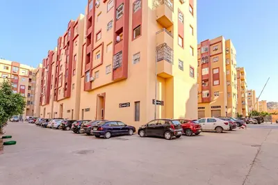 a row of cars parked in front of a building at Grand Appartement avec Balcon Marrakech in Oulad Akkou