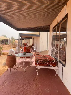 a patio with a table and chairs and a table at Luxury Desertcamp in Merdani