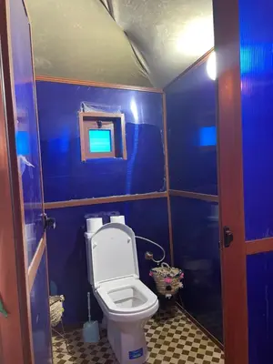 a small bathroom with a toilet and a blue wall at Luxury Desertcamp in Merdani