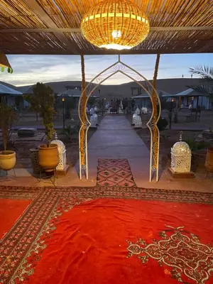 a tent with a red rug and a chandelier at Luxury Desertcamp in Merdani