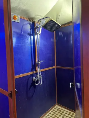 a shower in a bathroom with a blue wall at Luxury Desertcamp in Merdani