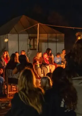 a group of people sitting in a tent at night at Desertwhispercamp in Merzouga