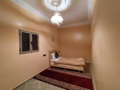 a room with a bed and a window and a ceiling at Desert Dream Apartment in Merzouga