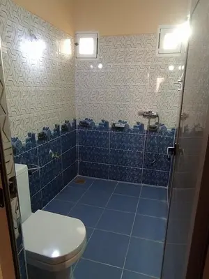 a bathroom with a toilet and a blue tile floor at Desert Dream Apartment in Merzouga