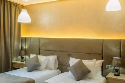 two beds in a hotel room with white pillows at Hôtel Reda Zagora in Zagora