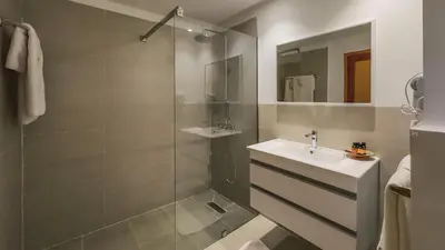 a bathroom with a glass shower and a sink at Hôtel Reda Zagora in Zagora