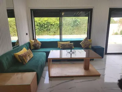 a living room with a green couch and a coffee table at Villa Paradis Fès