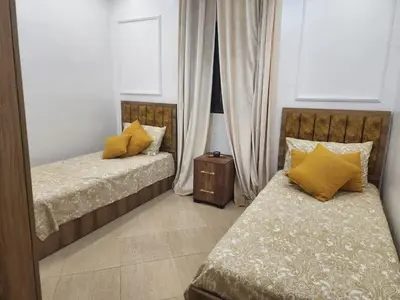 a bedroom with two beds with yellow pillows at Villa Paradis Fès
