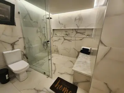 a white bathroom with a shower and a toilet at Villa Paradis Fès