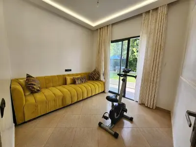 a living room with a yellow couch and a treadmill at Villa Paradis Fès