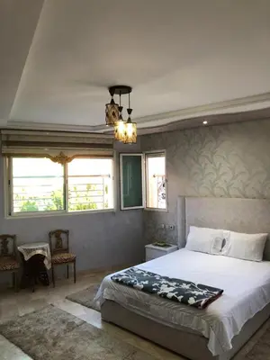 a bedroom with a large bed and two windows at Nas fez in Fès