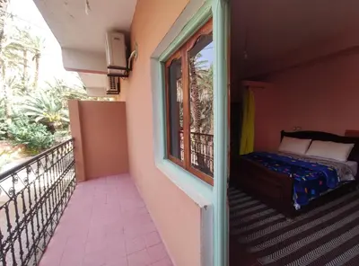 a balcony with a bed and a window at Le LAC Auberge Camping Todra in Tinerhir
