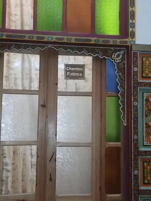 a door with a window with a sign on it at Maison Soulaîmi in Fès