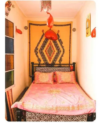 a bedroom with a bed with a red head board at Maison Soulaîmi in Fès