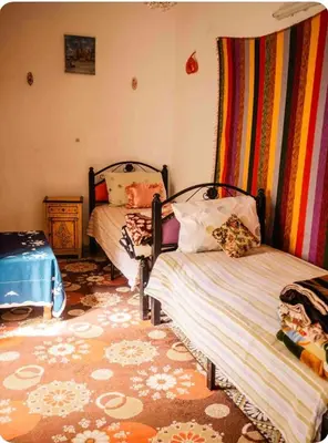 a bedroom with two beds and a dresser in it at Maison Soulaîmi in Fès