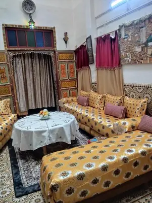 a living room with couches and a table at Maison Soulaîmi in Fès