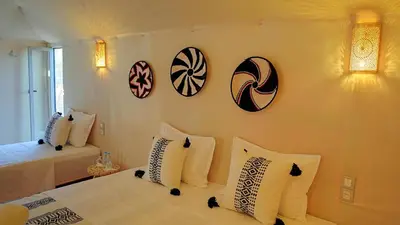 a bedroom with a bed with white pillows and pictures on the wall at Sahara Spirit luxury Camp in Merzouga